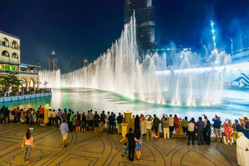 People walking in Dubai Mall with shopping bags near Dubai Fountain